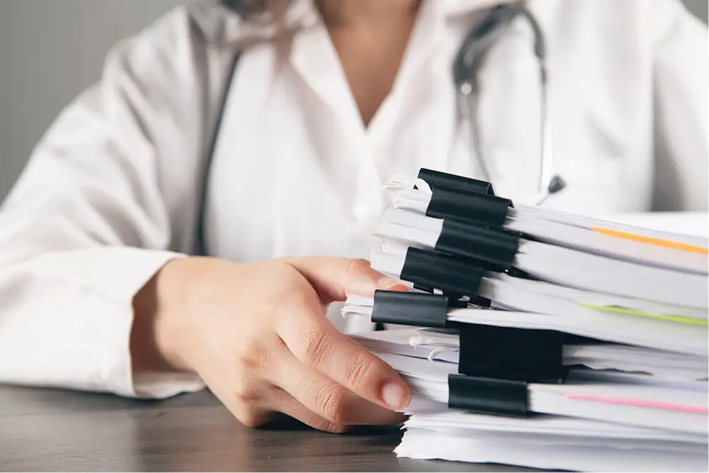 médecin avec pile de dossier